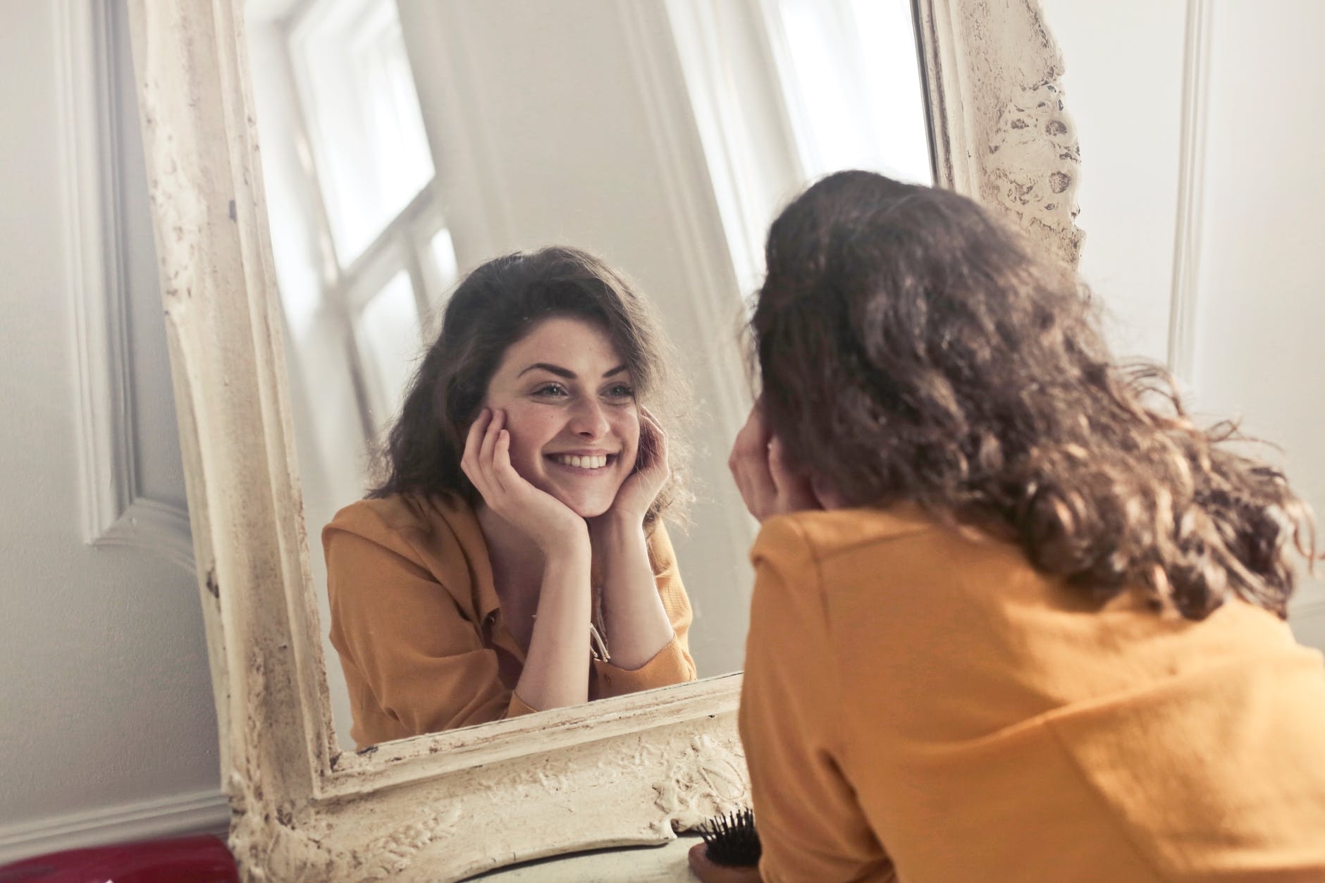 Woman looking in mirror smiling