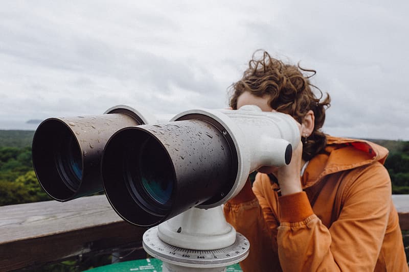 Woman looking through tourism binoculars