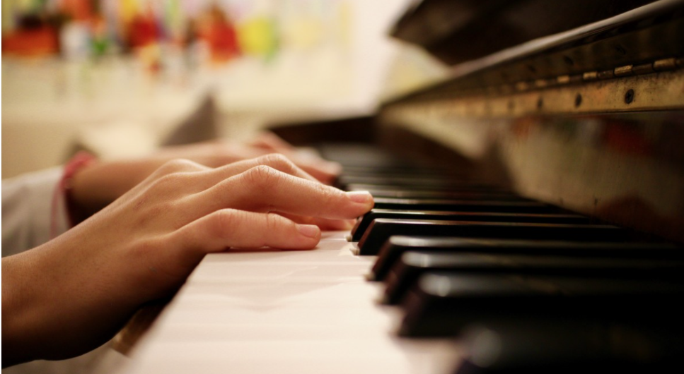 Hands resting on piano keys