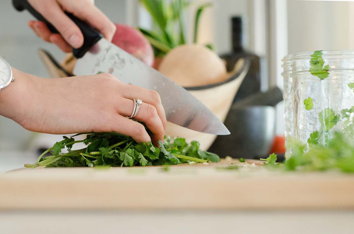 Woman cutting parsley with a chef’s knife